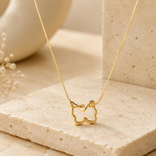 Papillon pendant necklace resting on a travertine block in daylight